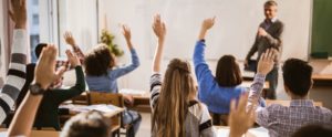 nursing students raising hands in classroom